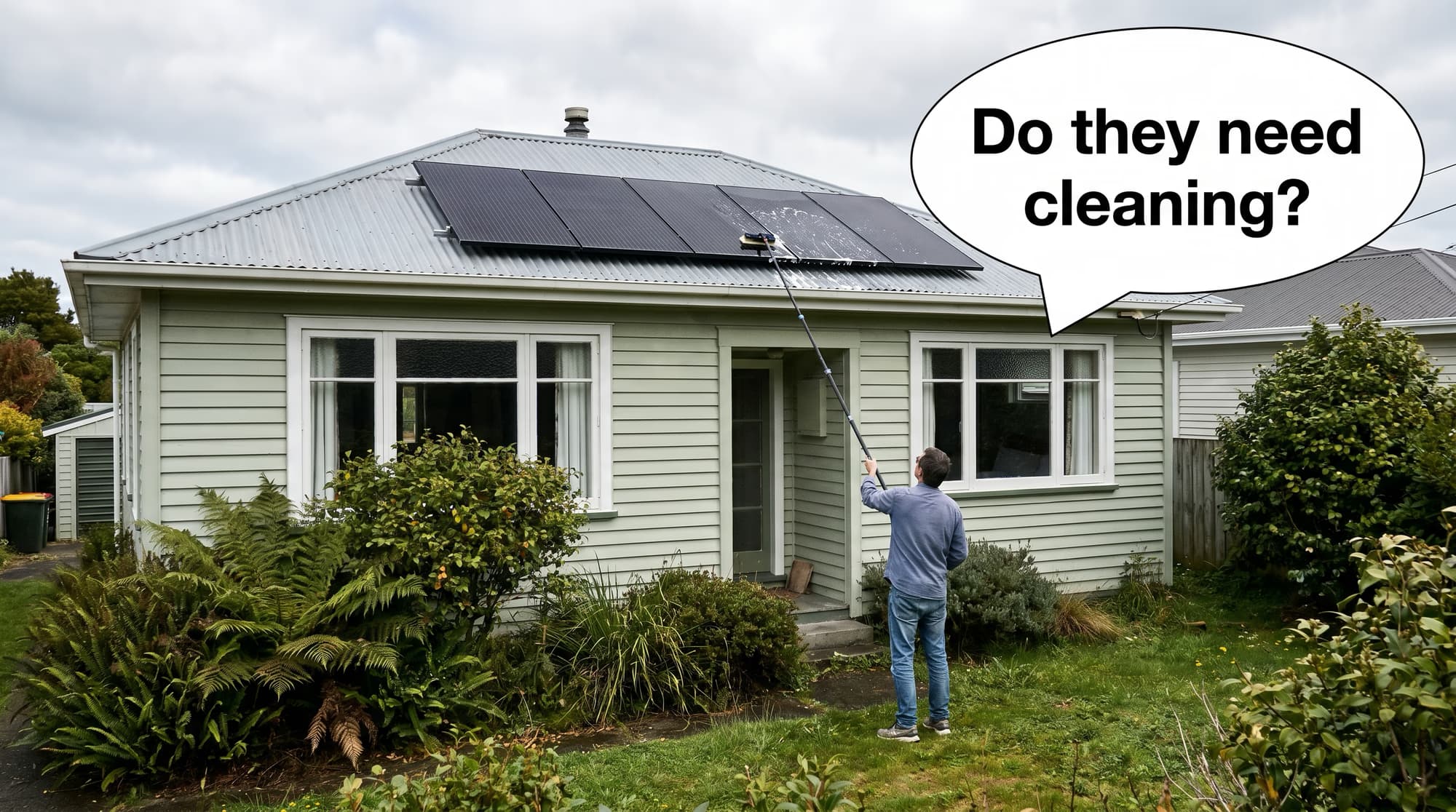 NZ homeowner on the front lawn using a long telescopic water-fed brush to clean all-black solar panels on the roof, speech bubble asking do they need cleaning
