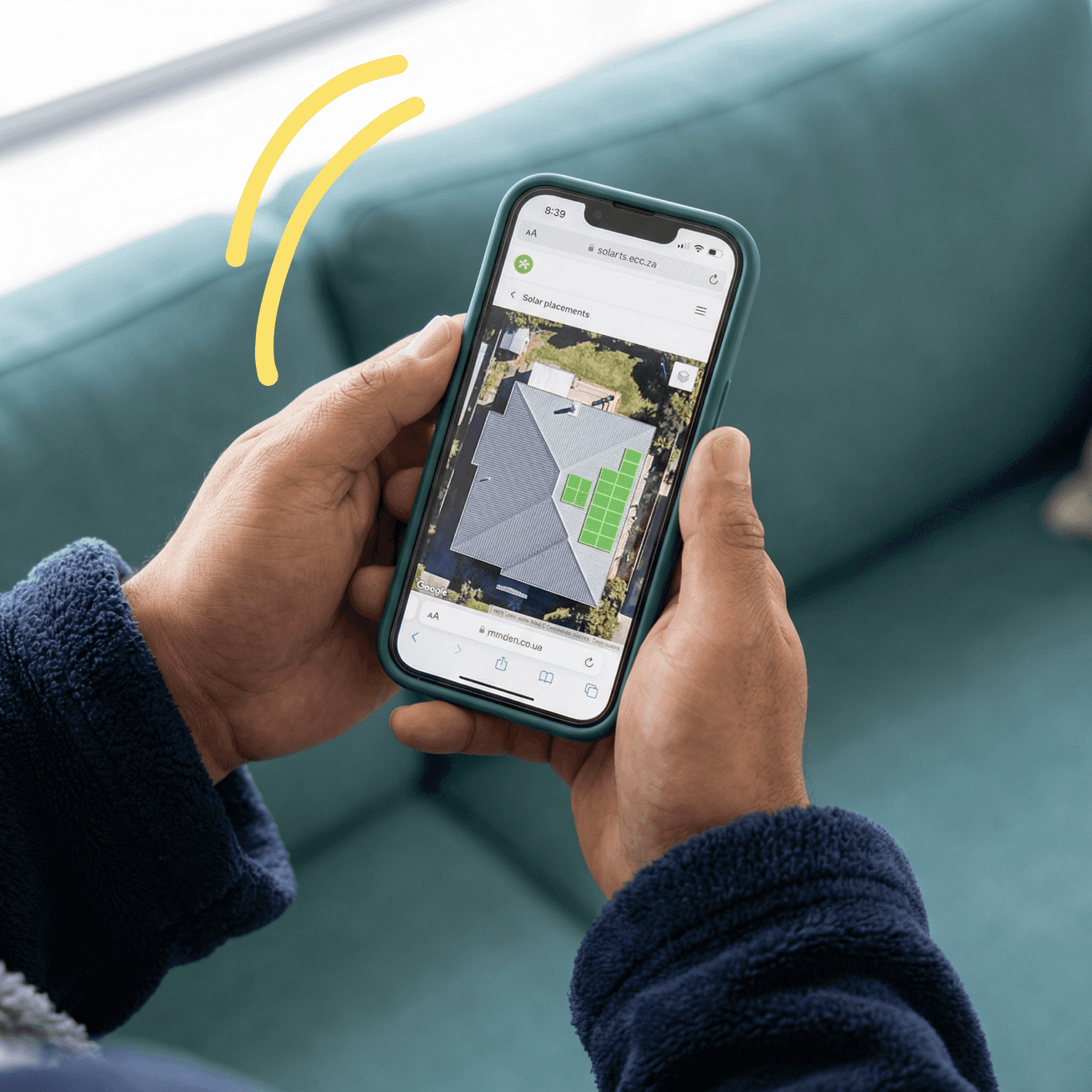 Hands holding phone showing satellite roof map with solar panel placements