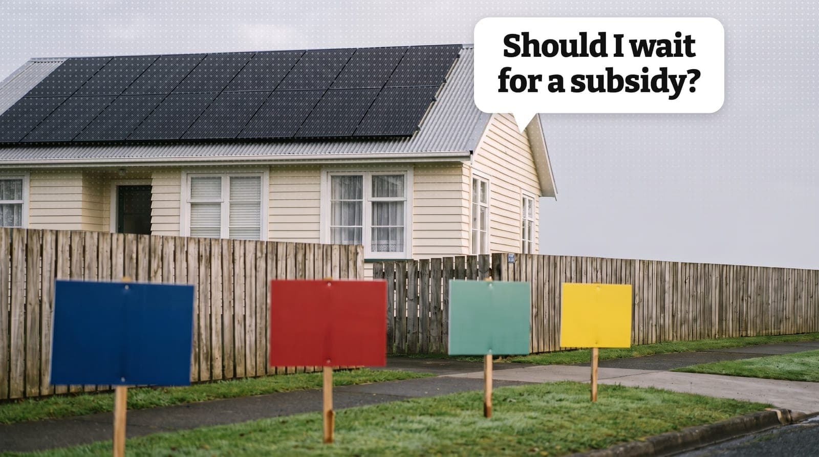 The roof of a New Zealand suburban house with solar panels, photographed from the street, with a row of election hoardings on the berm in front of it