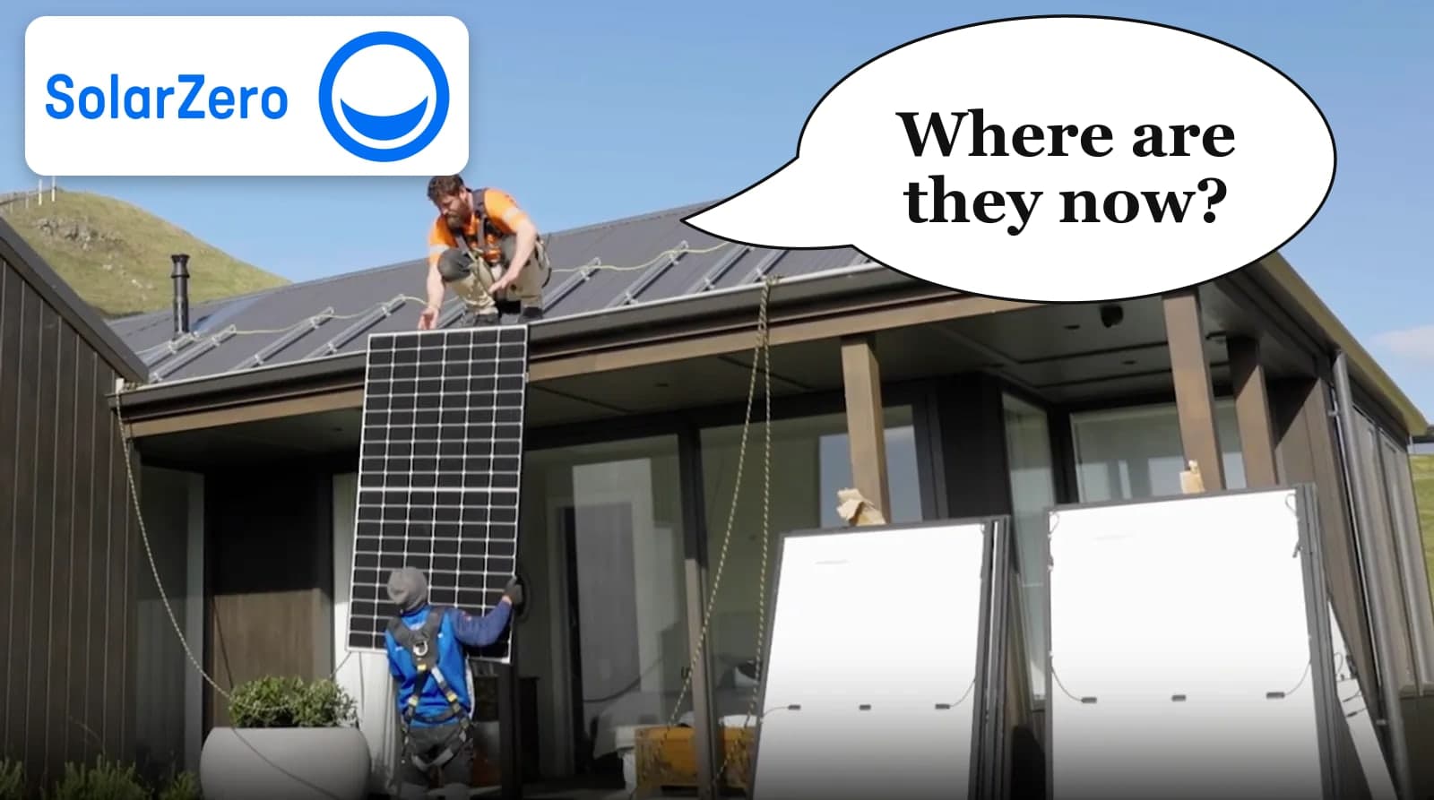 Two installers fitting a solar panel to the roof of a dark weatherboard home in New Zealand, with the SolarZero logo and a speech bubble asking where they are now.