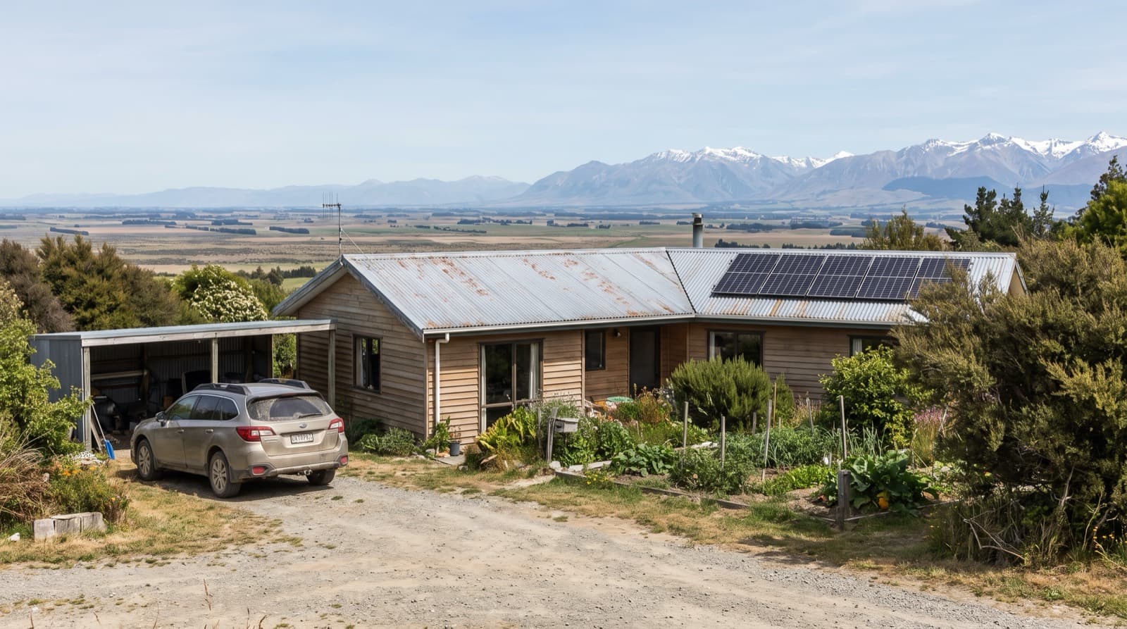Solar panels on a Canterbury Plains weatherboard home with snow-capped Southern Alps in the distance