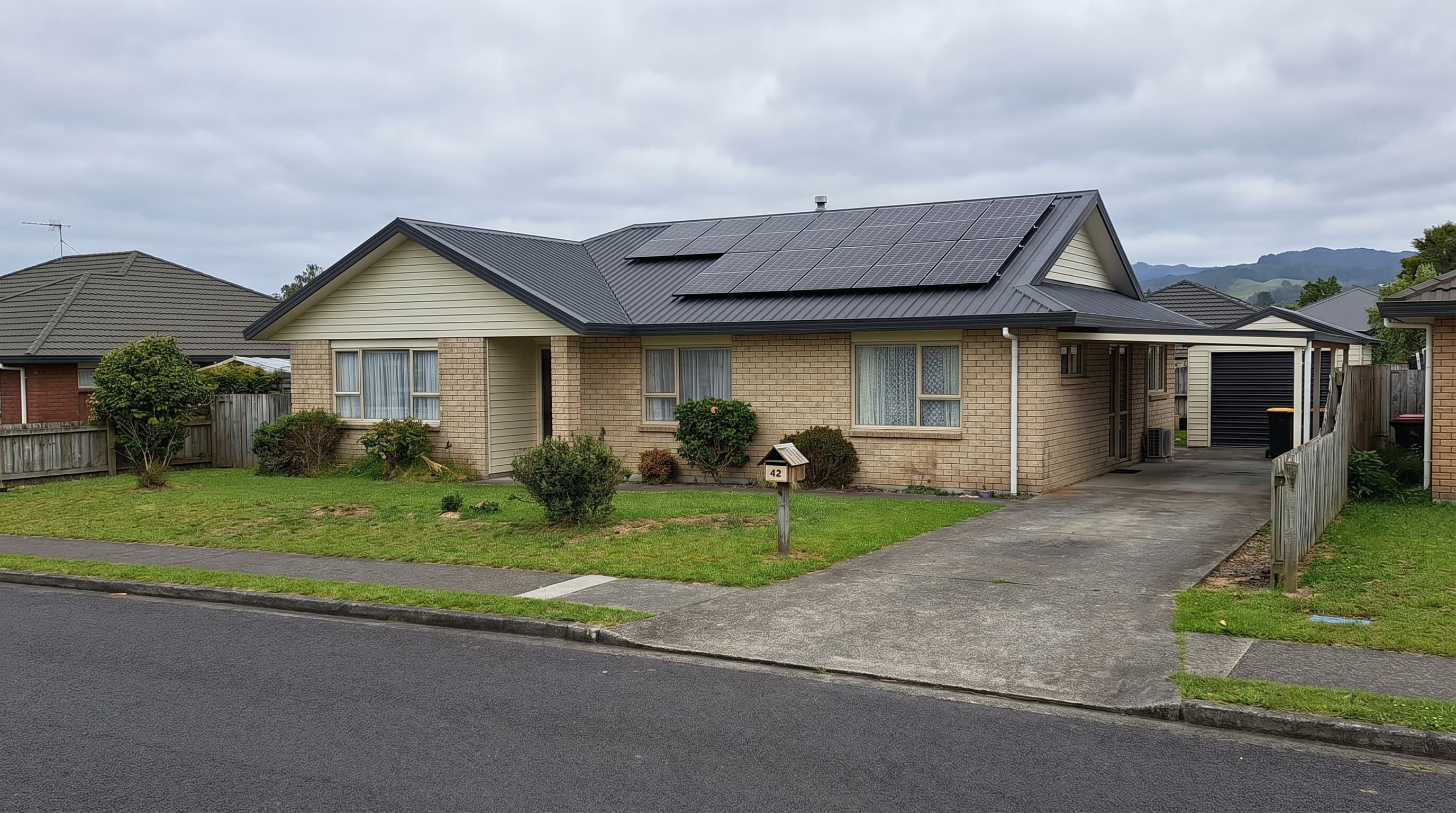 Solar panels on a Waikato weatherboard farmhouse with rolling green dairy hills behind