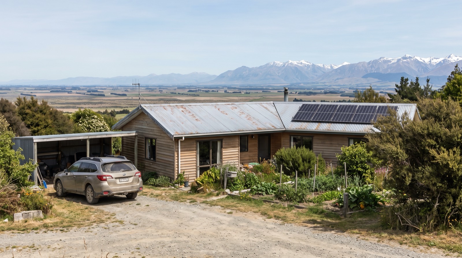 Solar panels on a Canterbury Plains weatherboard home with snow-capped Southern Alps in the distance